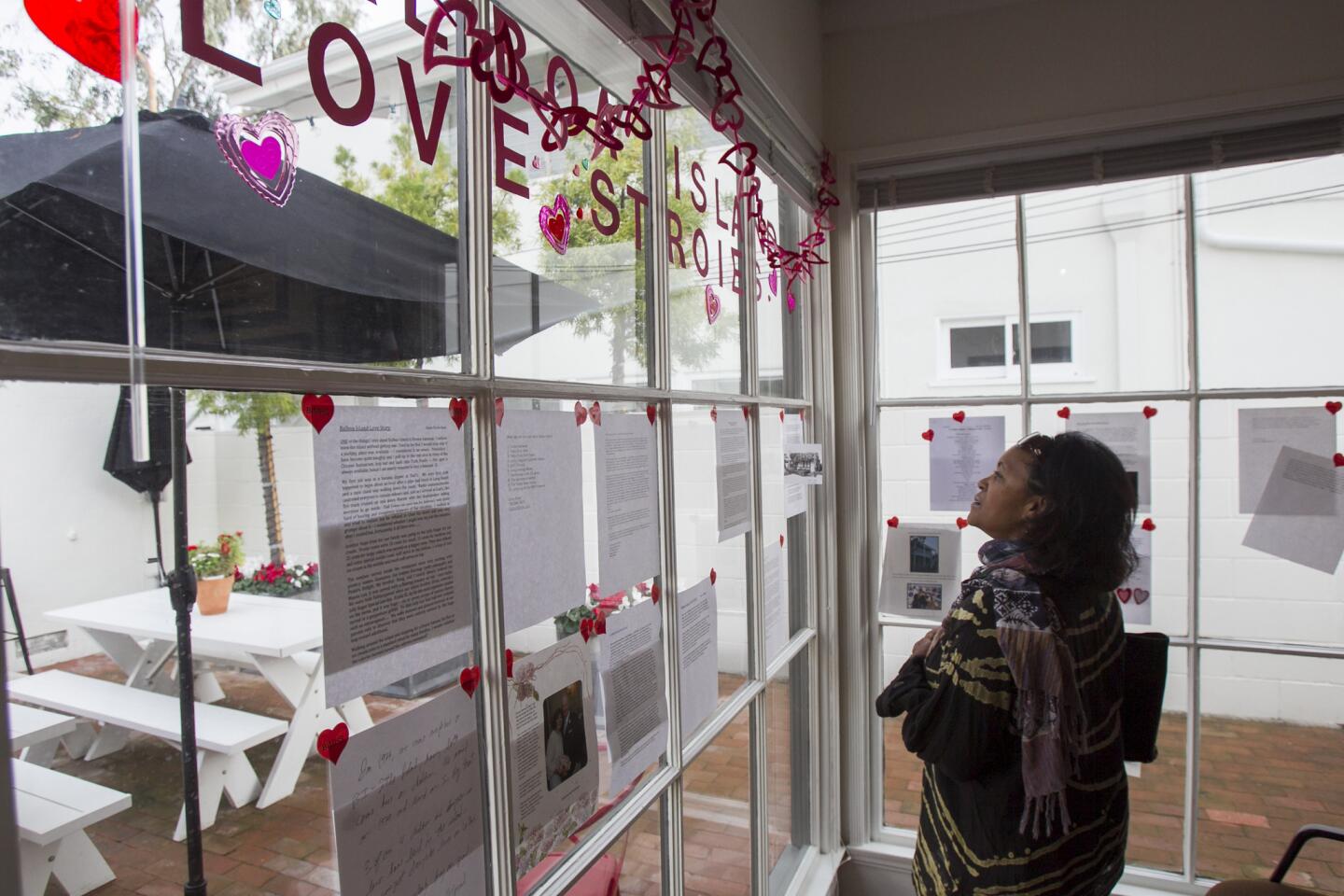 Shirley Jordan looks at a window covered with love stories about Balboa Island at the Balboa Island Museum & Historical Society on Saturday, February 15. (Scott Smeltzer, Daily Pilot)