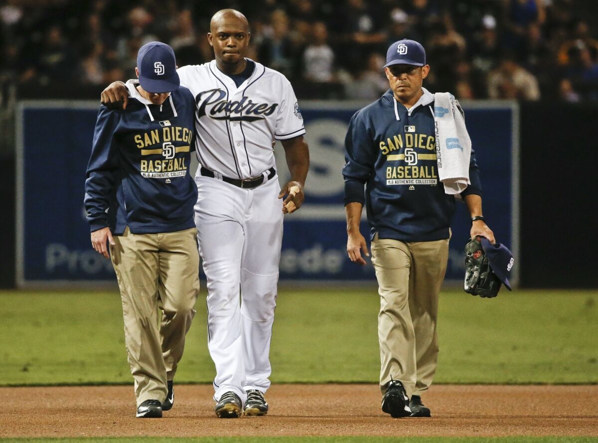 Padres left fielder Justin Upton helped from the field after being injured crashing into the wall fielding a hit by Milwaukee Brewers' Logan Schafer in the first inning of a baseball game Wednesday, Sept. 30, 2015, in San Diego.
