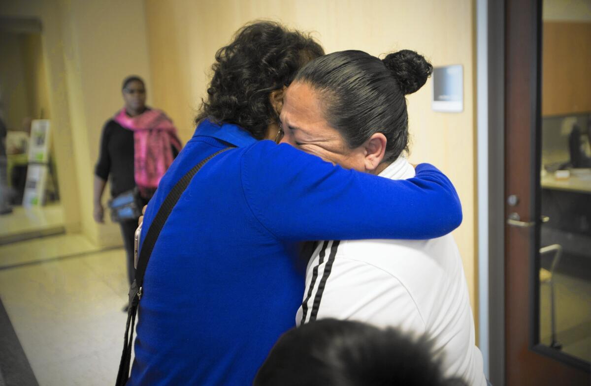 Damaris Martinez, left, a volunteer chaplain at the San Diego County Medical Examiner's Office, comforts Maribel Rodriguez, whose daughter went missing more than two years ago.