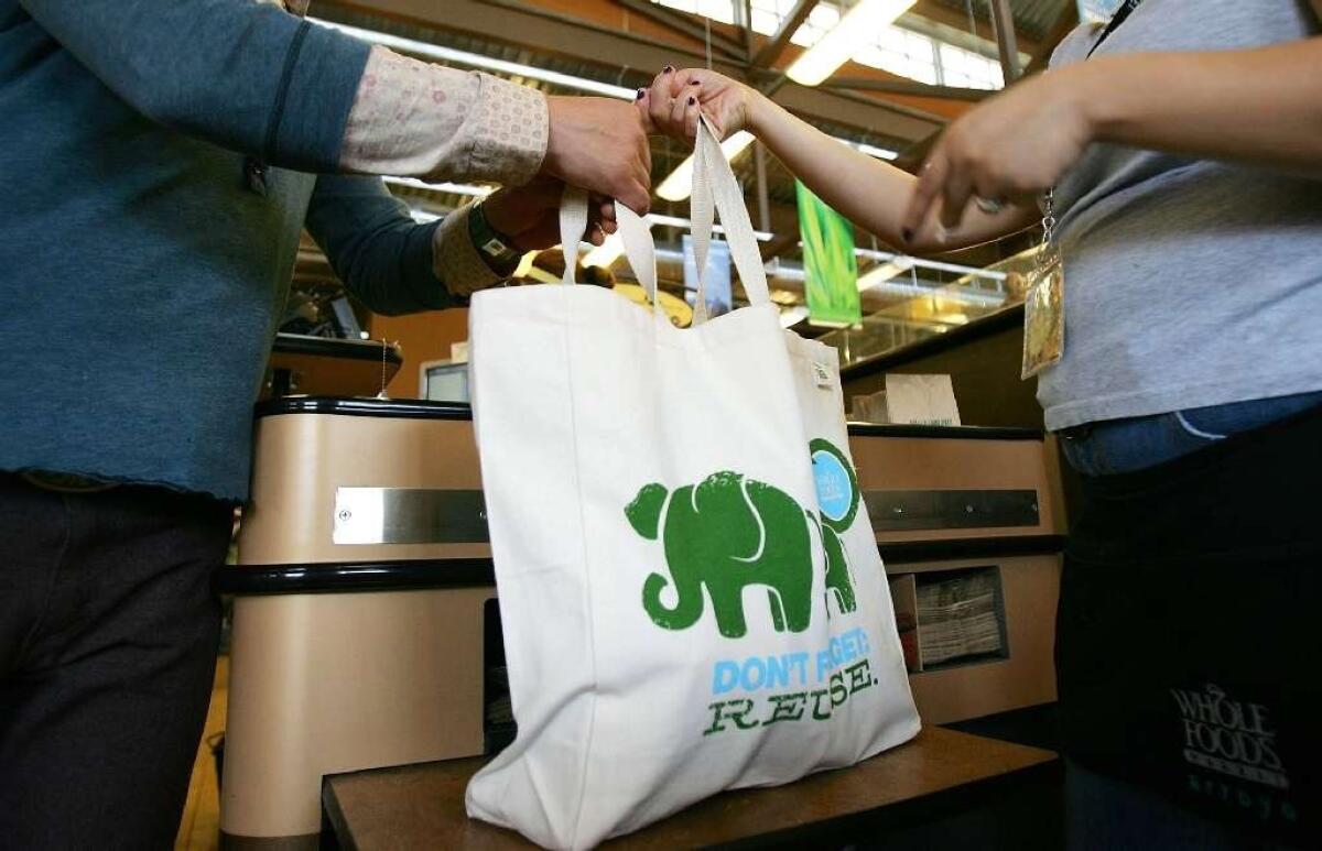 A shopper carries purchases in a reusable tote.