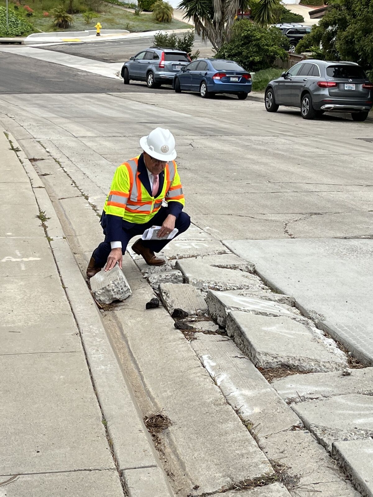 Councilmember Joe LaCava checks out crumbled concrete on Vantage Way.