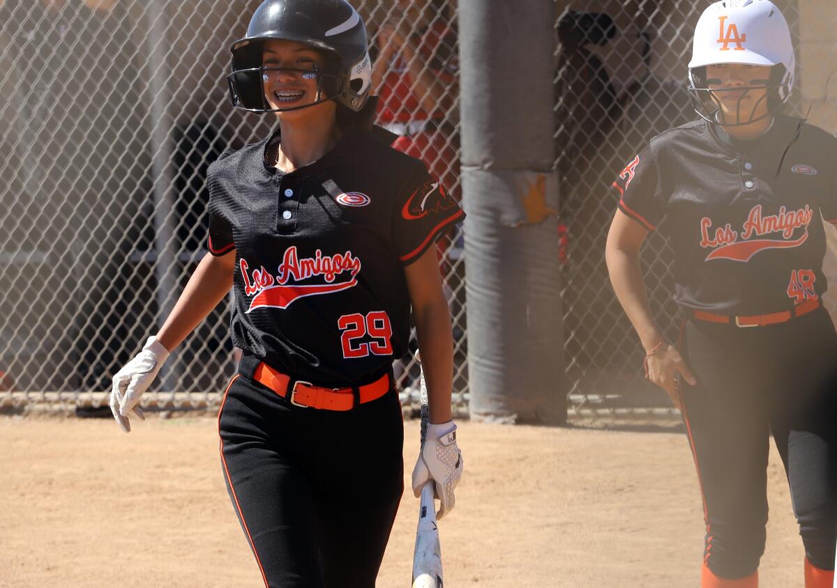Los Amigos' Leah Lemusu (29) is all smiles after scoring the first run of the game against A.B. Miller on Tuesday.