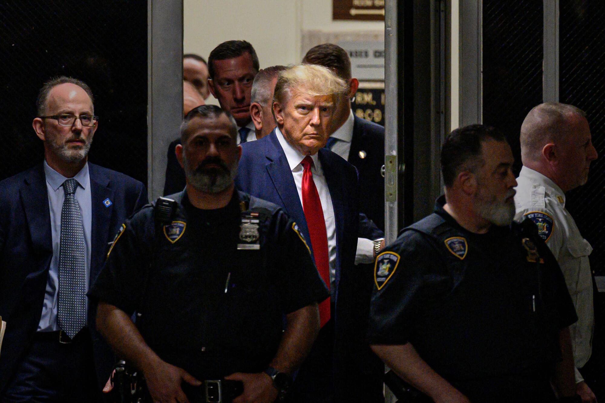 Surrounded by security, Donald Trump makes his way inside the Manhattan curthouse.