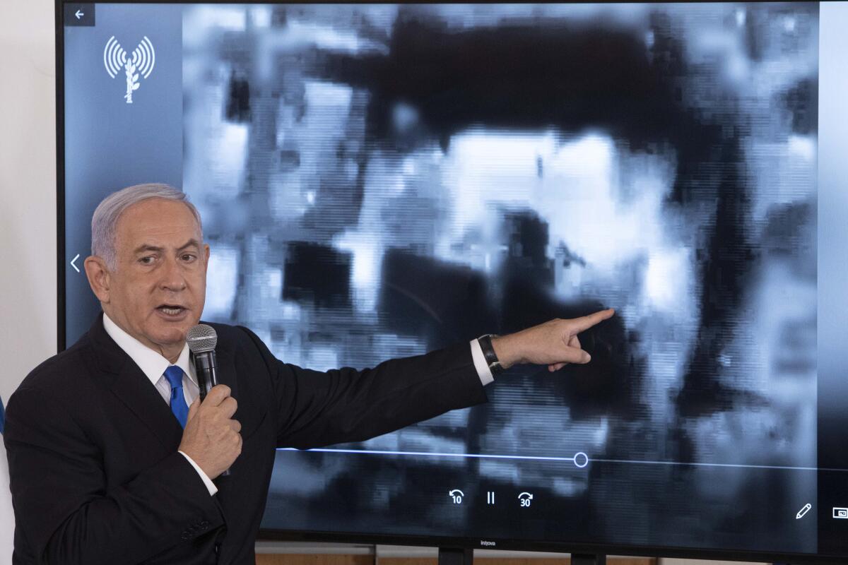Israeli Prime Minister Benjamin Netanyahu gestures as he shows a slideshow 