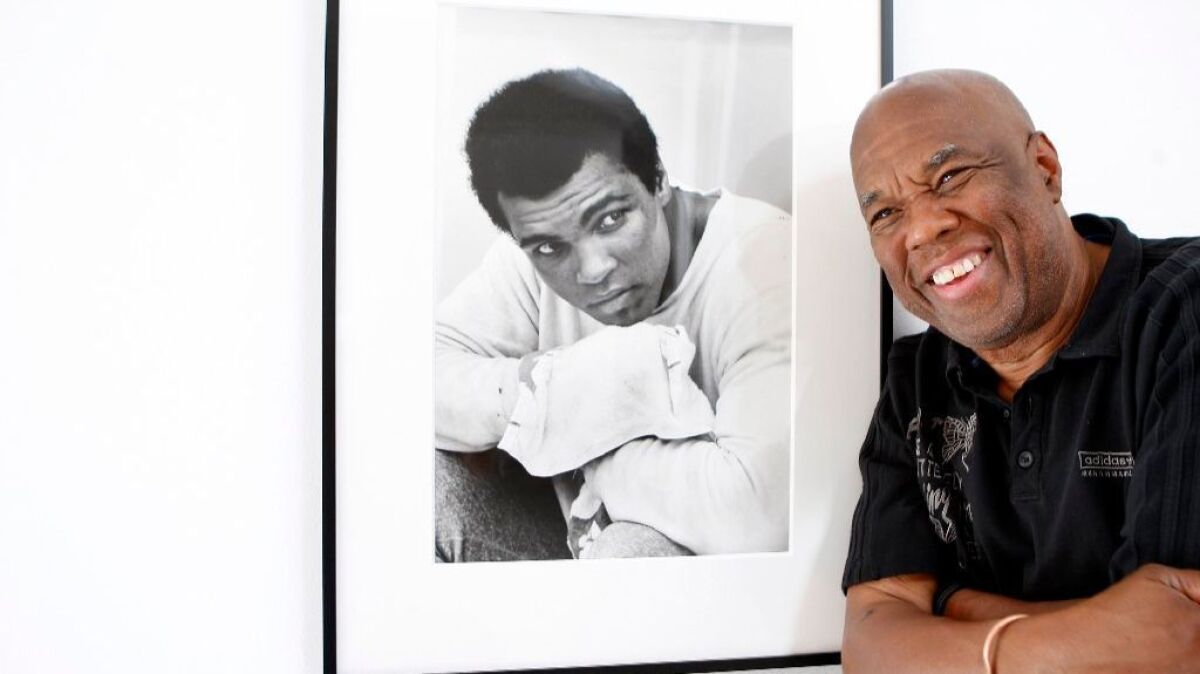 Howard Bingham, the photographer for heavyweight boxing champion Muhammad Ali, poses with one of his portraits at a Hollywood gallery in 2008.