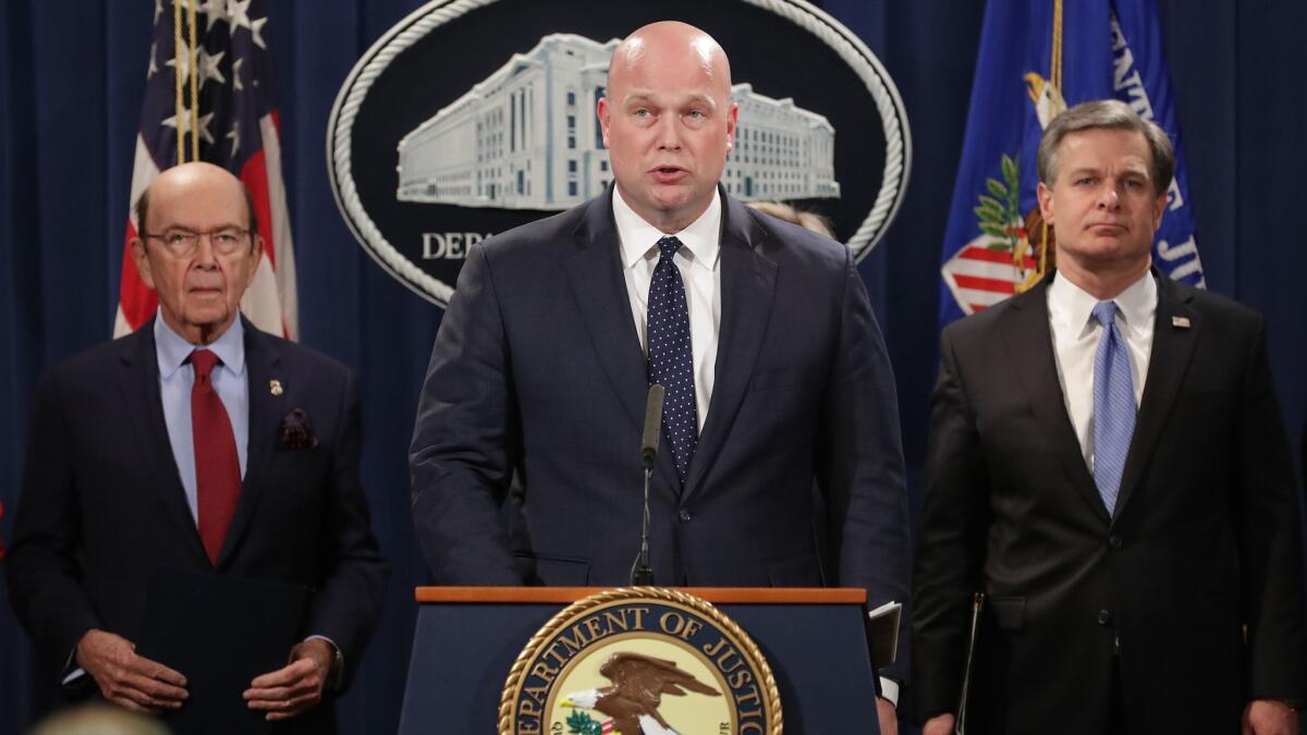 Acting U.S. Atty. Gen. Matthew Whitaker, center, announces new criminal charges against Chinese telecommunications giant Huawei on Monday.