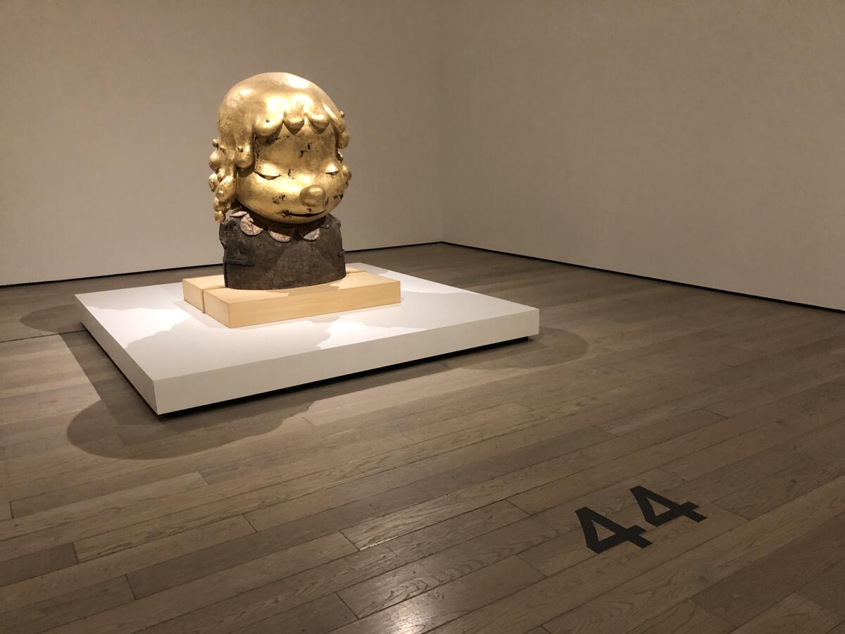 A golden sculpture in a gallery.