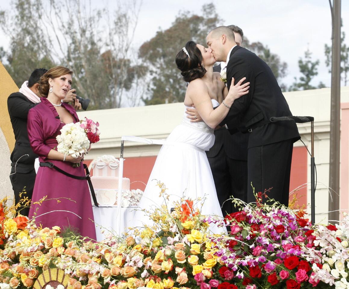 A married couple kisses atop the Farmer's Insurance Float at the 2013 Rose Parade in Pasadena on January 1, 2013.