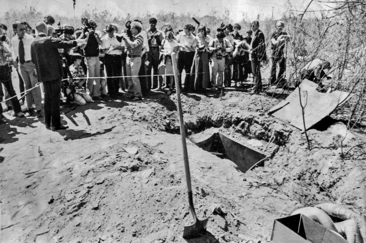 July 17, 1976: Alameda County Sheriff Tom Houchins briefs the news media at the Livermore quarry where the Chowchilla children were buried. They escaped through the shaft at lower right in this photo.