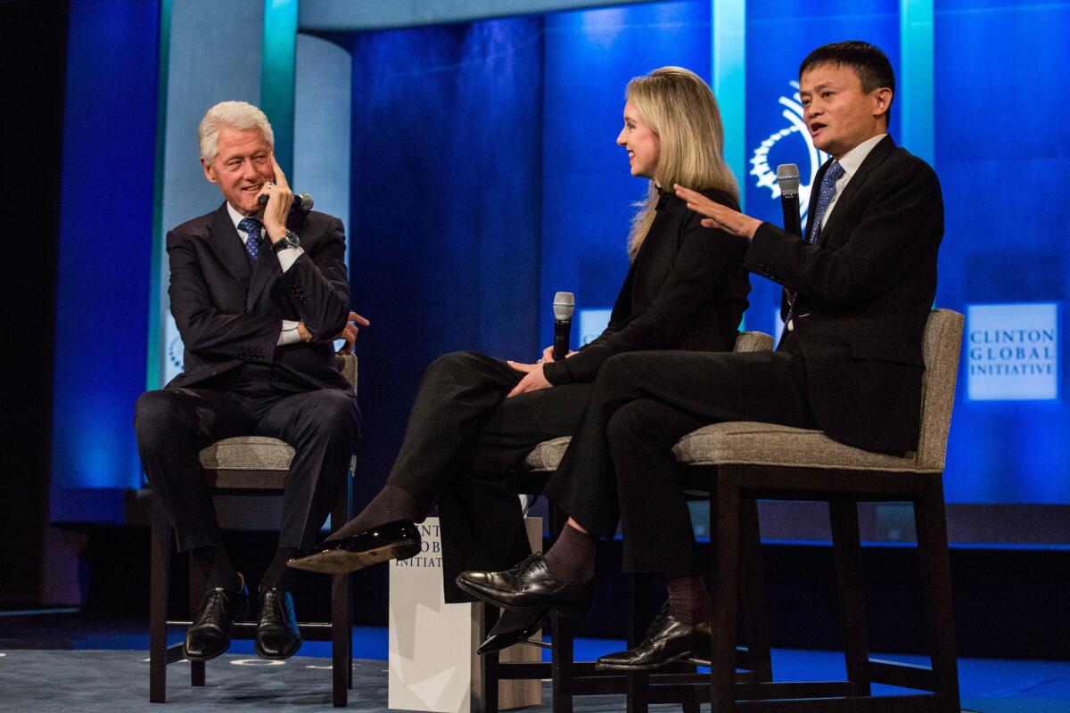 Put the excitement on hold for a moment: Elizabeth Holmes of beleaguered startup Theranos was flanked by former President Bill Clinton and Jack Ma, chairman of Alibaba Group, at a recent event sponsored by the Clinton Global Initiative.