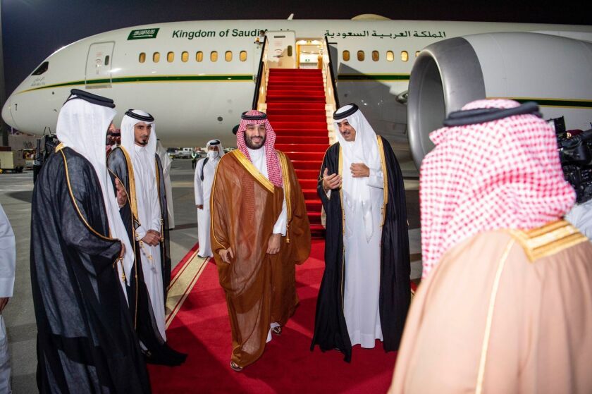 In this photo released by Saudi Royal Palace, Saudi Crown Prince Mohammed bin Salman, center left, is greeted by Qatar's Emir Sheikh Tamim bin Hamad Al Thani upon his arrival at Doha airport in Qatar late Wednesday, Dec. 8, 2021. Saudi Arabia's crown prince is in Qatar for the first time since the kingdom rallied other Arab states to end their years-long rift and embargo on the tiny Gulf state. (Bandar Aljaloud/Saudi Royal Palace via AP)