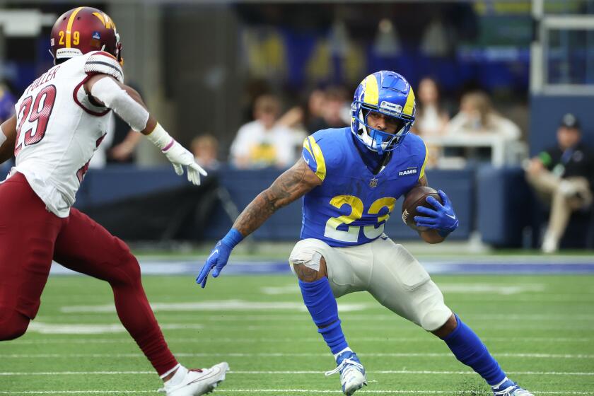 Rams running back Kyren Williams tries to avoid Washington's Kendall Fuller (29).