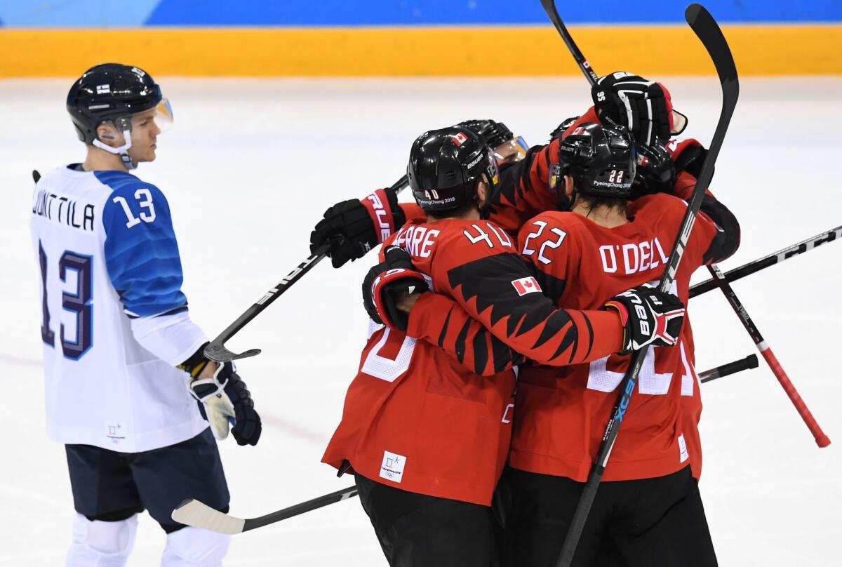 Canadian players celebrate a goal as Finland's Julius Junttila looks on during the men's quarterfinals.