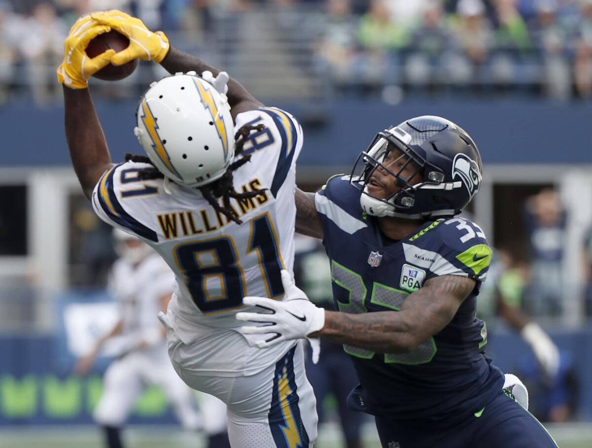 Chargers receiver Mike Williams, trying to haul in a pass against Seattle's Tedric Thompson, had a highlight-reel touchdown catch Sunday at CenturyLink Field in Seattle.