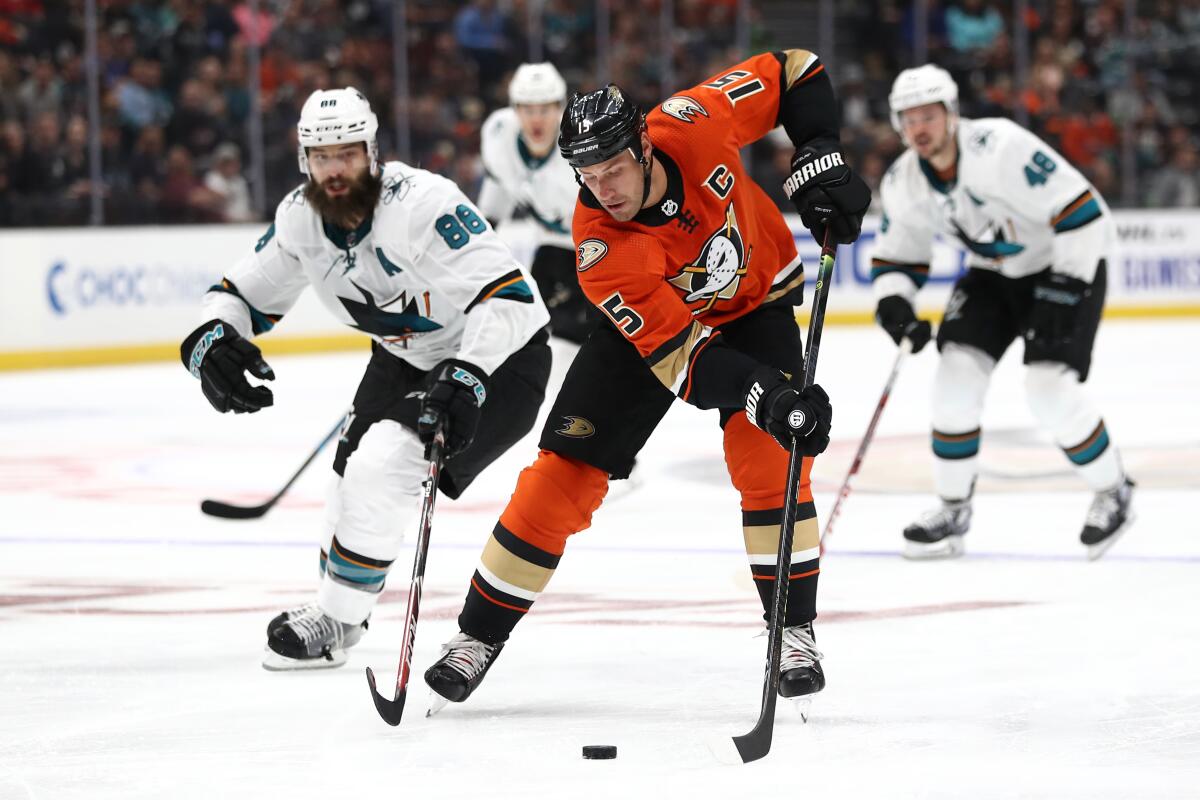 The Ducks' Ryan Getzlaf controls the puck past the Sharks' Brent Burns at Honda Center on Saturday night.