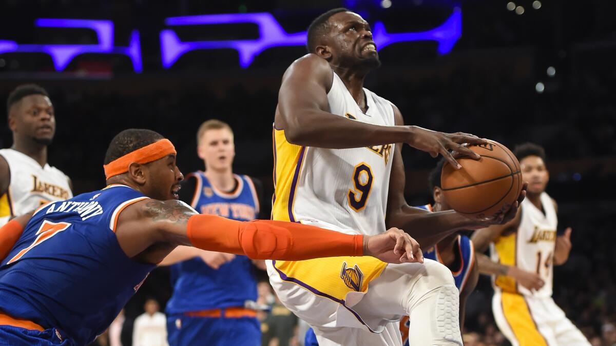 Lakers forward Luol Deng draws a foul from Knicks forward Carmelo Anthony as he drives to the basket during a Dec. 11 game at Staples Center.