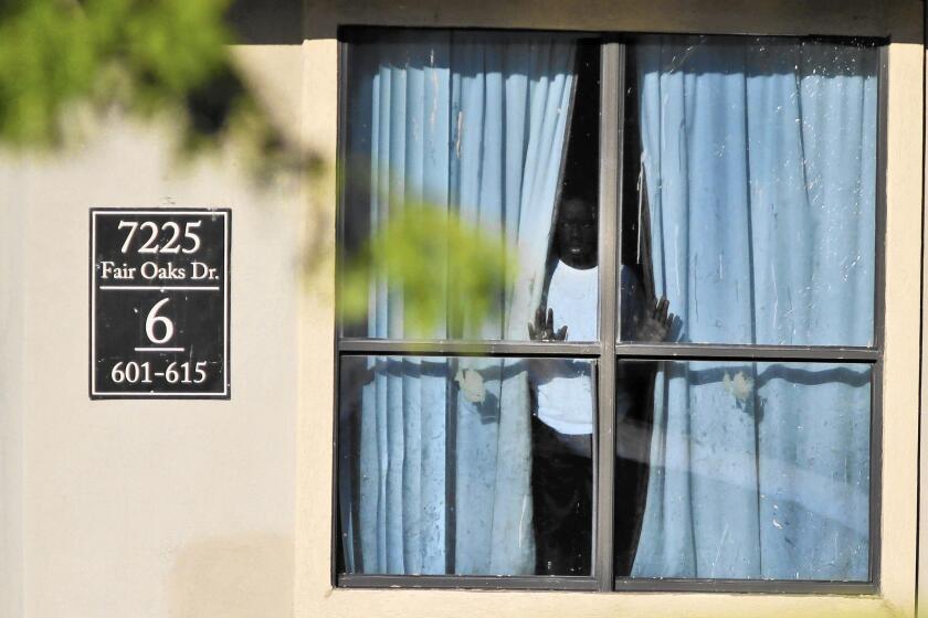 A child looks out from an apartment in Dallas where relatives of Thomas Eric Duncan, the Liberian who died of Ebola after arriving, are living.