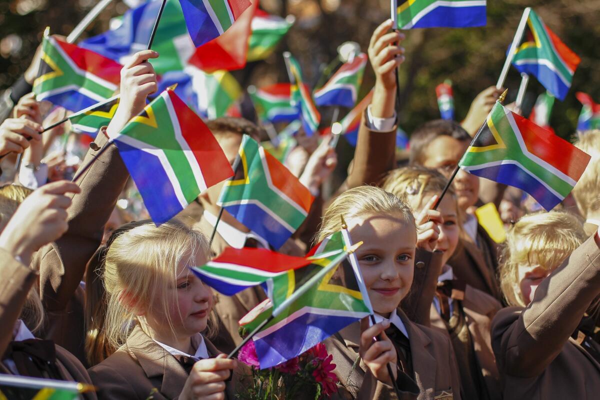 South African schoolchildren wave flags for former President Nelson Mandela outside the hospital in Pretoria where he is being treated.