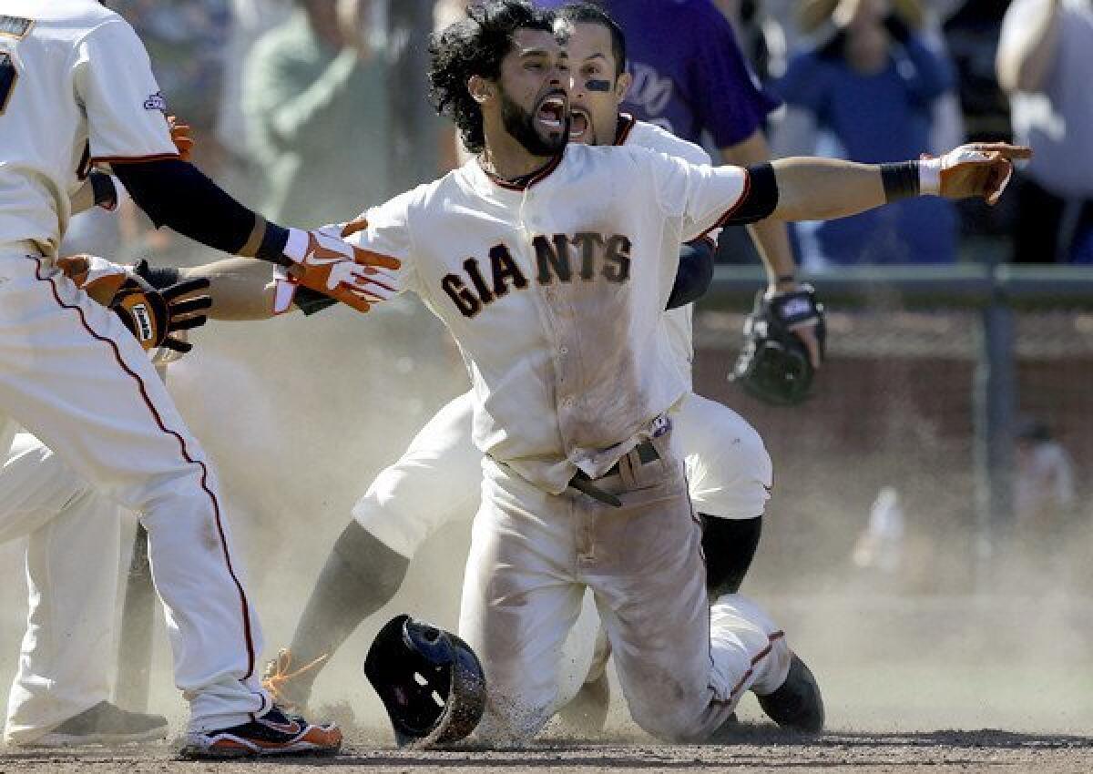 San Francisco's Angel Pagan gives the safe sign after hitting a game-winning inside-the-park home run against the Colorado Rockies on Saturday at AT&T Park.