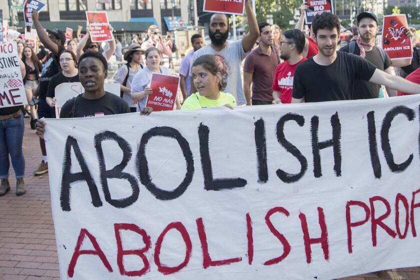Therese Patricia Okoumou, bottom left, takes part in a demonstration calling for the Immigration and Customs Enforcement, or ICE, to be abolished and an end to mass incarceration, Friday, June 29, 2018, in New York. Okoumou pleaded not guilty Thursday, July 5, 2018, to misdemeanor trespassing and disorderly conduct for climbing the base of the Statue of Liberty on a busy Fourth of July in what prosecutors called a "dangerous stunt." (AP Photo/Mary Altaffer)
