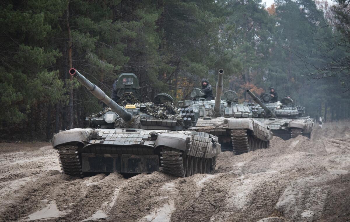 Ukrainian soldiers on captured Russian tanks