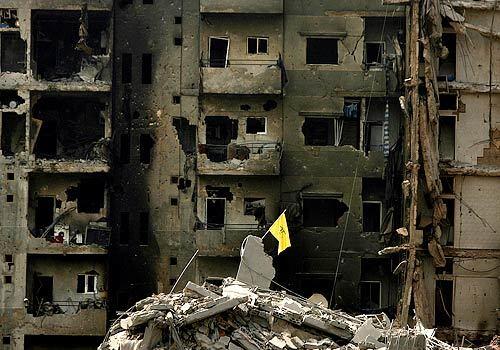 A Hezbollah flag stands among rubble in the town of Dahieh, a suburb of Southern Beirut.