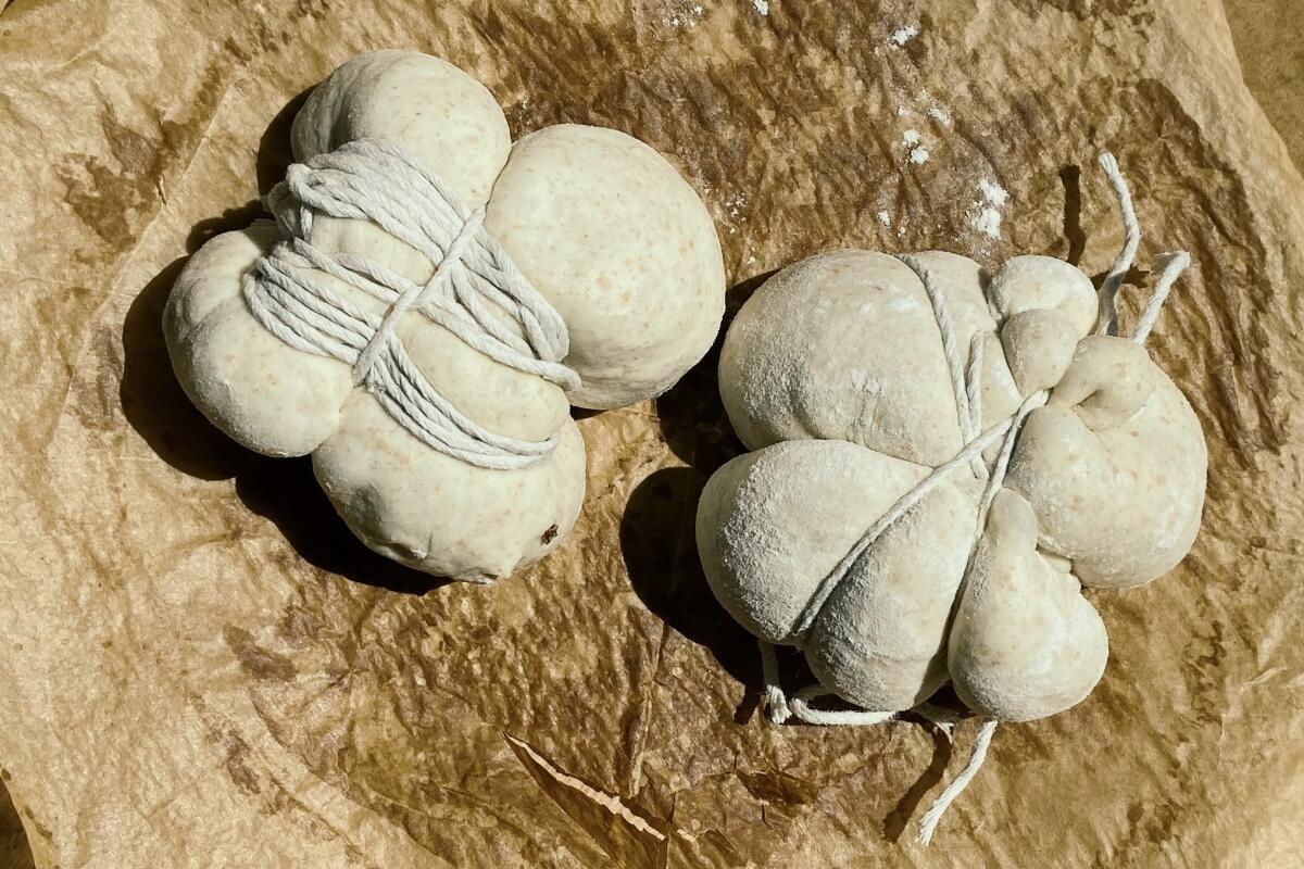 Bound by string, dough balls for cherry blossom wild yeast loaves look like bulbous sculpture.