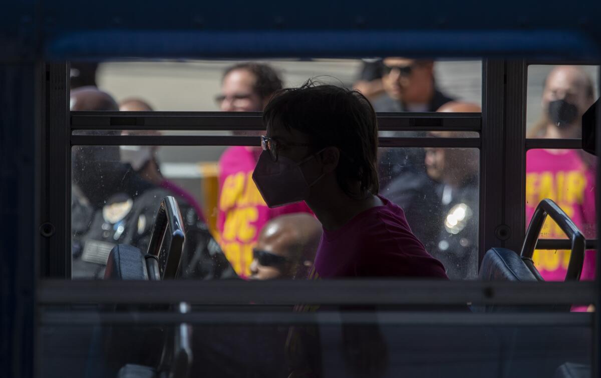 An arrested protester sits on a police bus