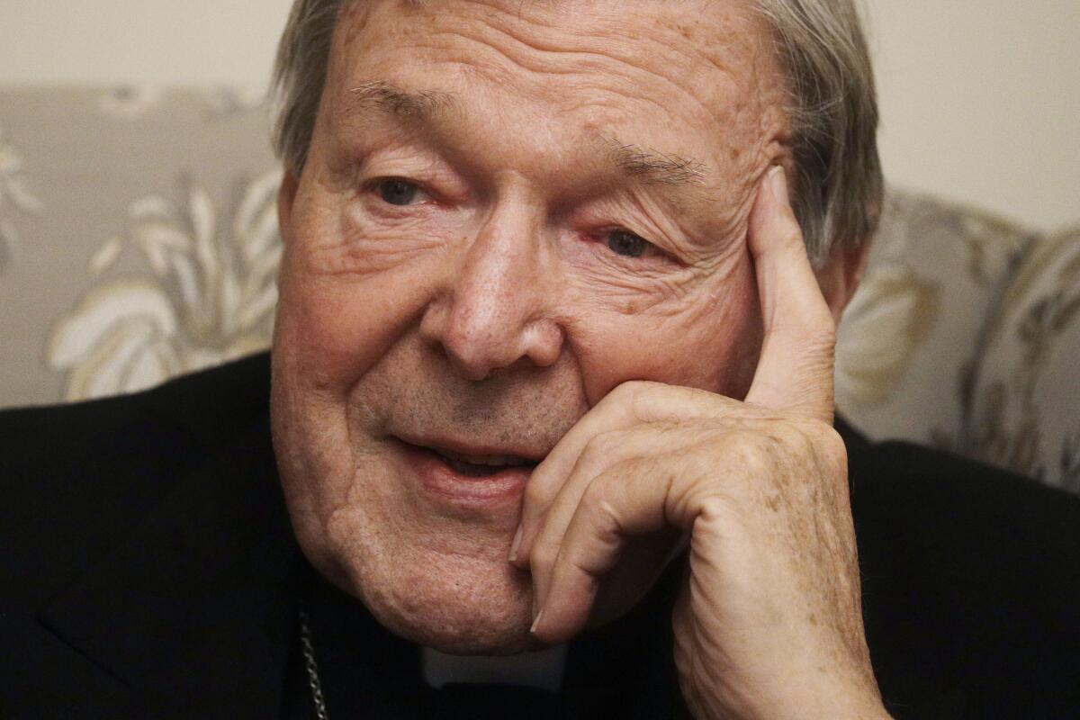 Cardinal George Pell looks on while answering questions.