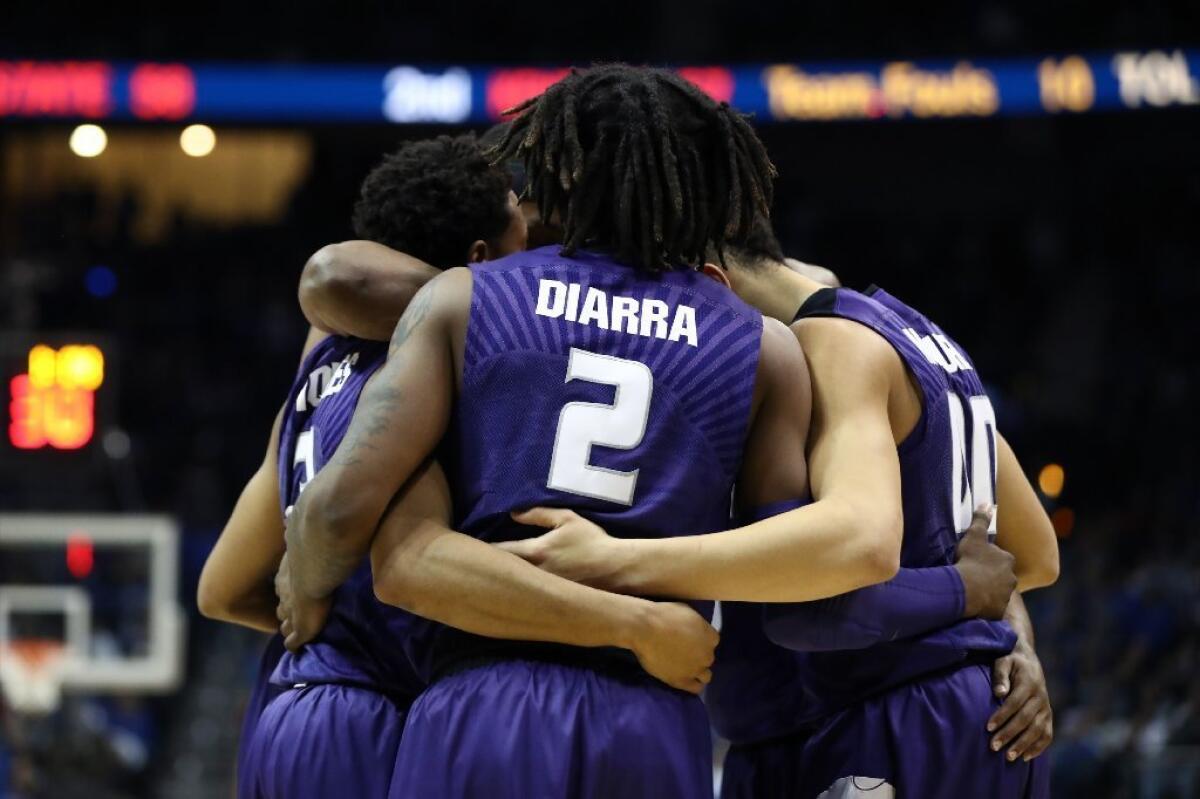 Kansas State's Cartier Diarra huddles with teammates during the second half against Kentucky.