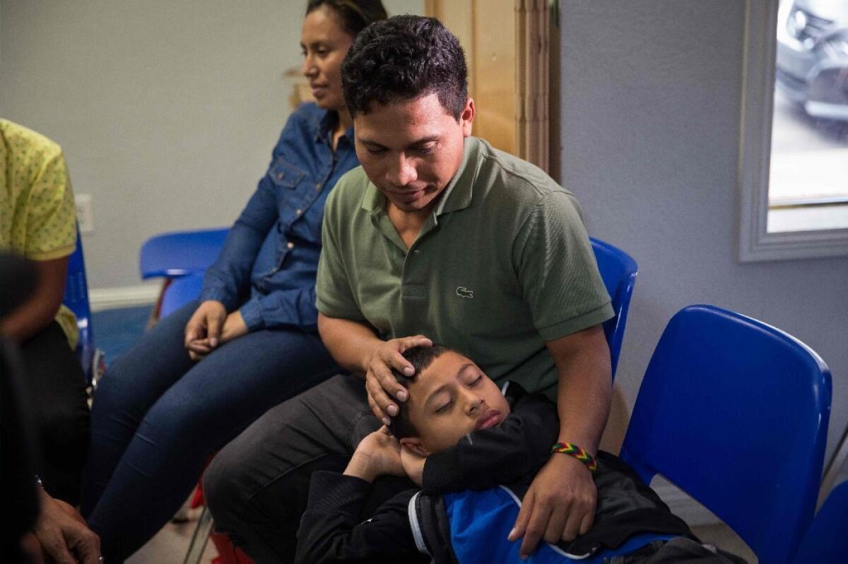 An immigrant from El Salvador and his 10-year-old son pass the time after being released from detention in McAllen, Texas. on June 17, 2018. The man said he was separated from his son while in detention.