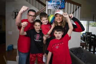 SAN DIEGO, CA - MARCH 29: Four of the five members of the Robert family of Rancho Penasquitos are headed to Houston to watch the Final Four and be part of school history. Dad, Scott Robert, left, Jayce Robert, 11, Jude Robert, 3, (not going), Joey Robert, 9, foreground, right, and mom, Angie Robert, background right. Photographed Wednesday March 29, 2023. (Howard Lipin / For The San Diego Union-Tribune)