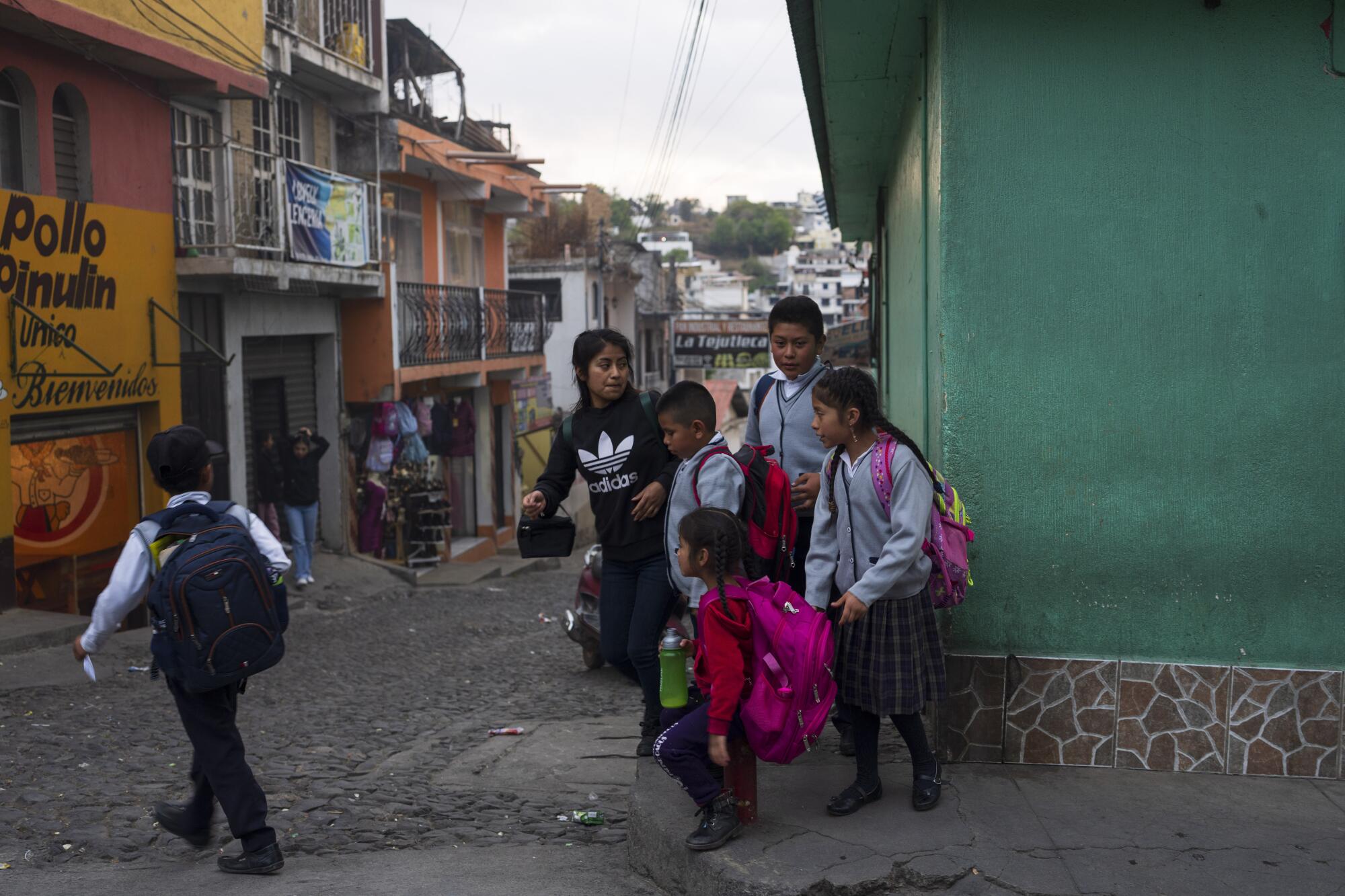 Children with backpacks walk home after school in Comitancillo, Guatemala