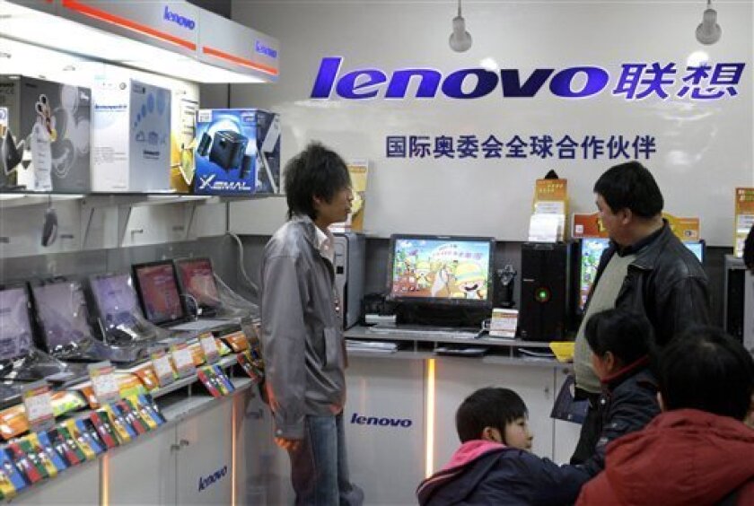 In this Jan 31, 2008 file photo, Chinese customers shop at a Lenovo shop in Beijing, China. Lenovo Group said on Friday, Nov. 7, 2008 its quarterly profit dived 78 percent as the global economic slowdown battered sales, and the PC maker said it will launch a restructuring with possible job cuts. (AP Photo/Andy Wong, FILE)
