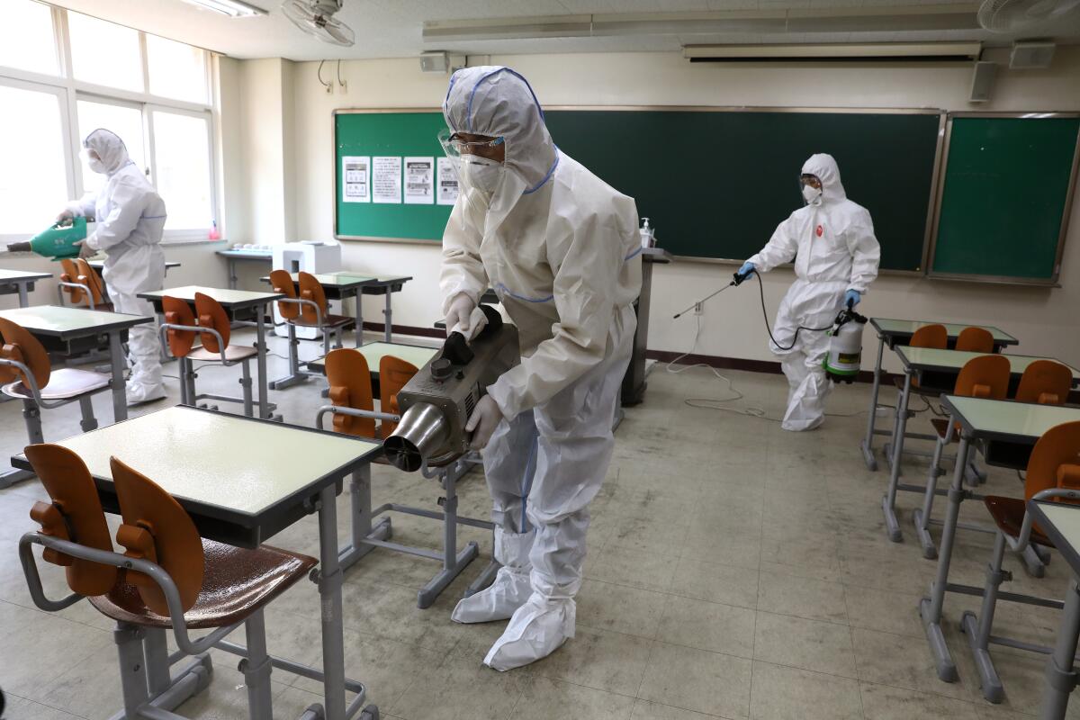 Health workers disinfect a classroom on May 11, 2020, ahead of a school reopening, now delayed after the latest cluster of cases linked to clubs in the Itaewon area of Seoul.