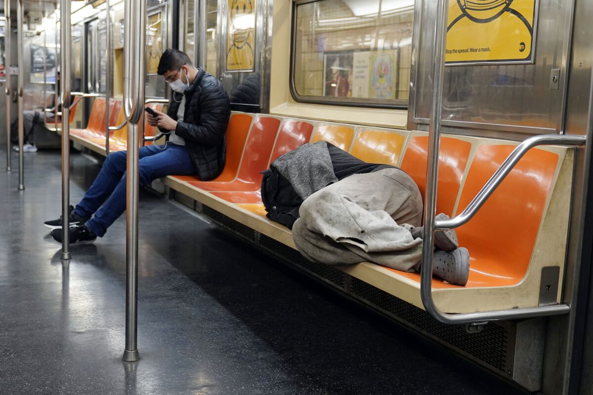 A man sleeps on a subway train in New York