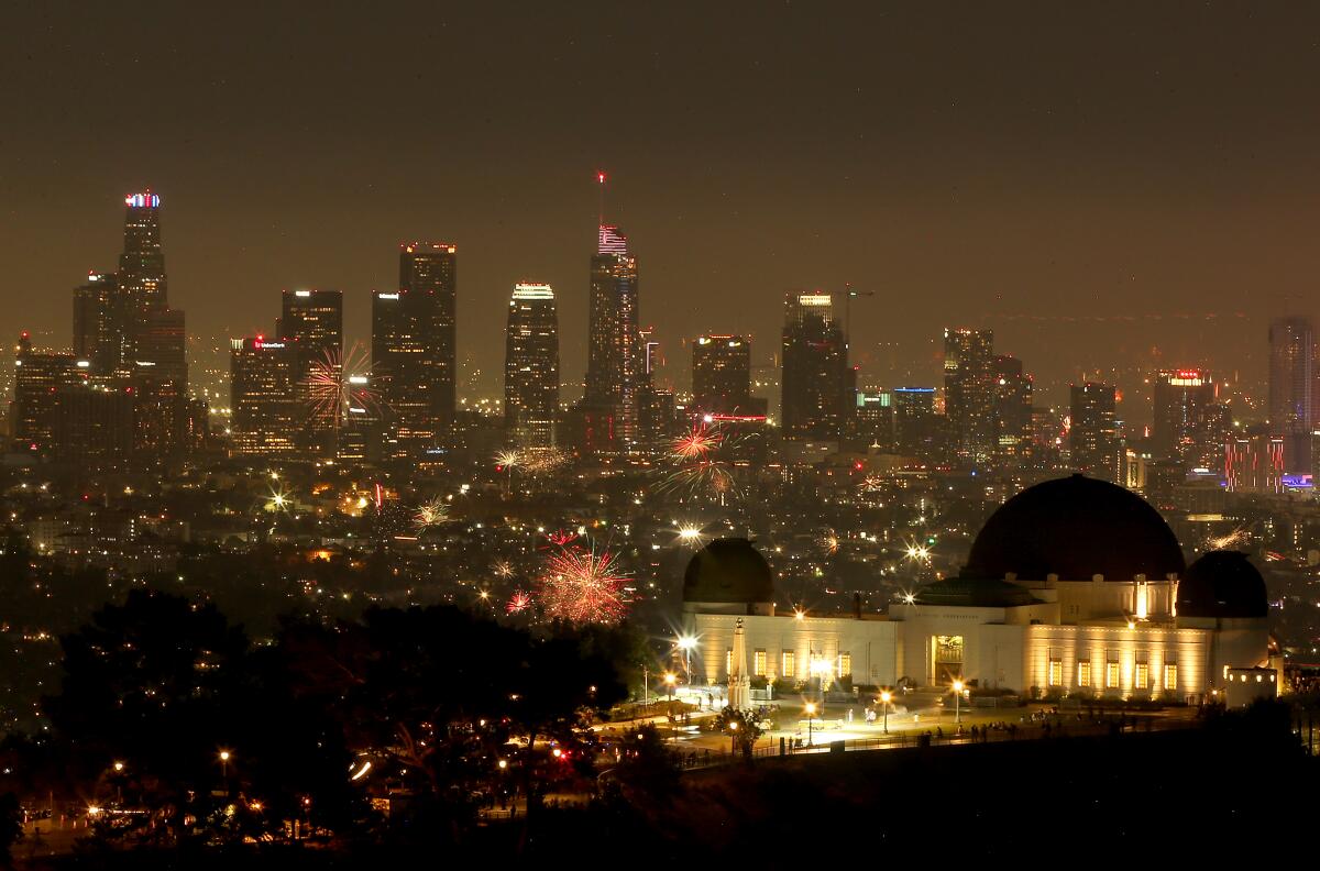 A city's skyline at night, with spots of fireworks.