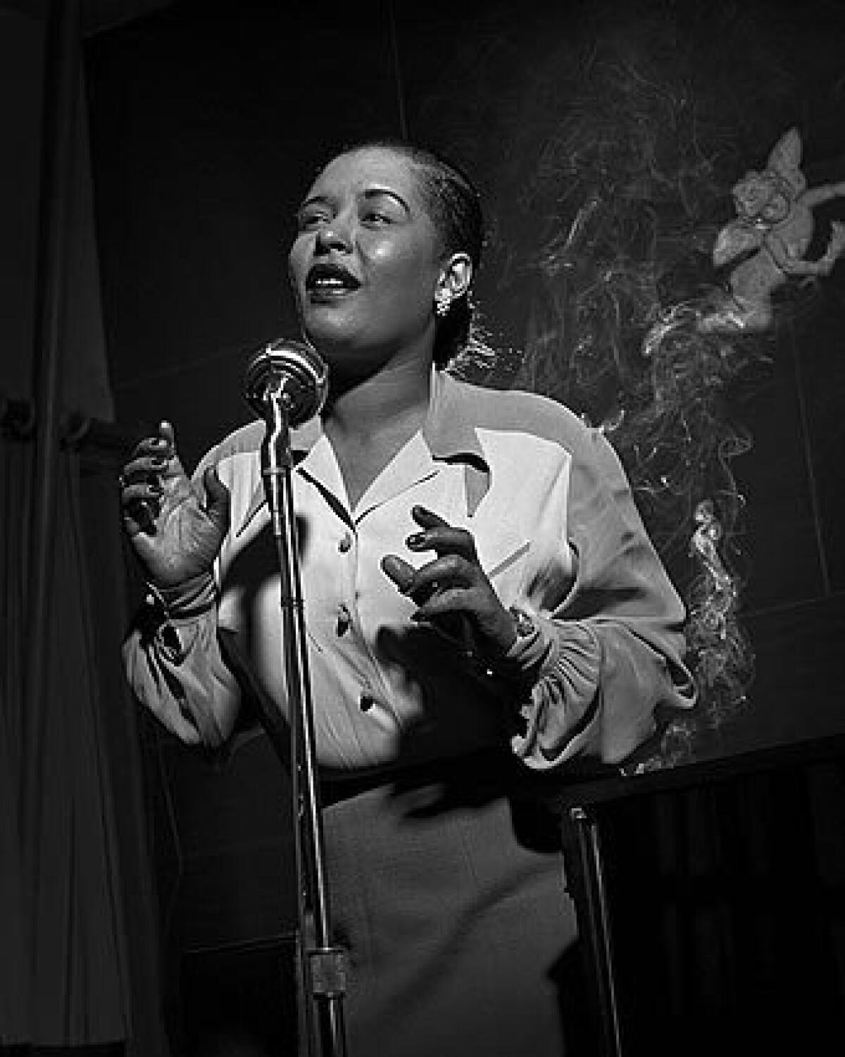 Billie Holiday performs at a microphone in New York.