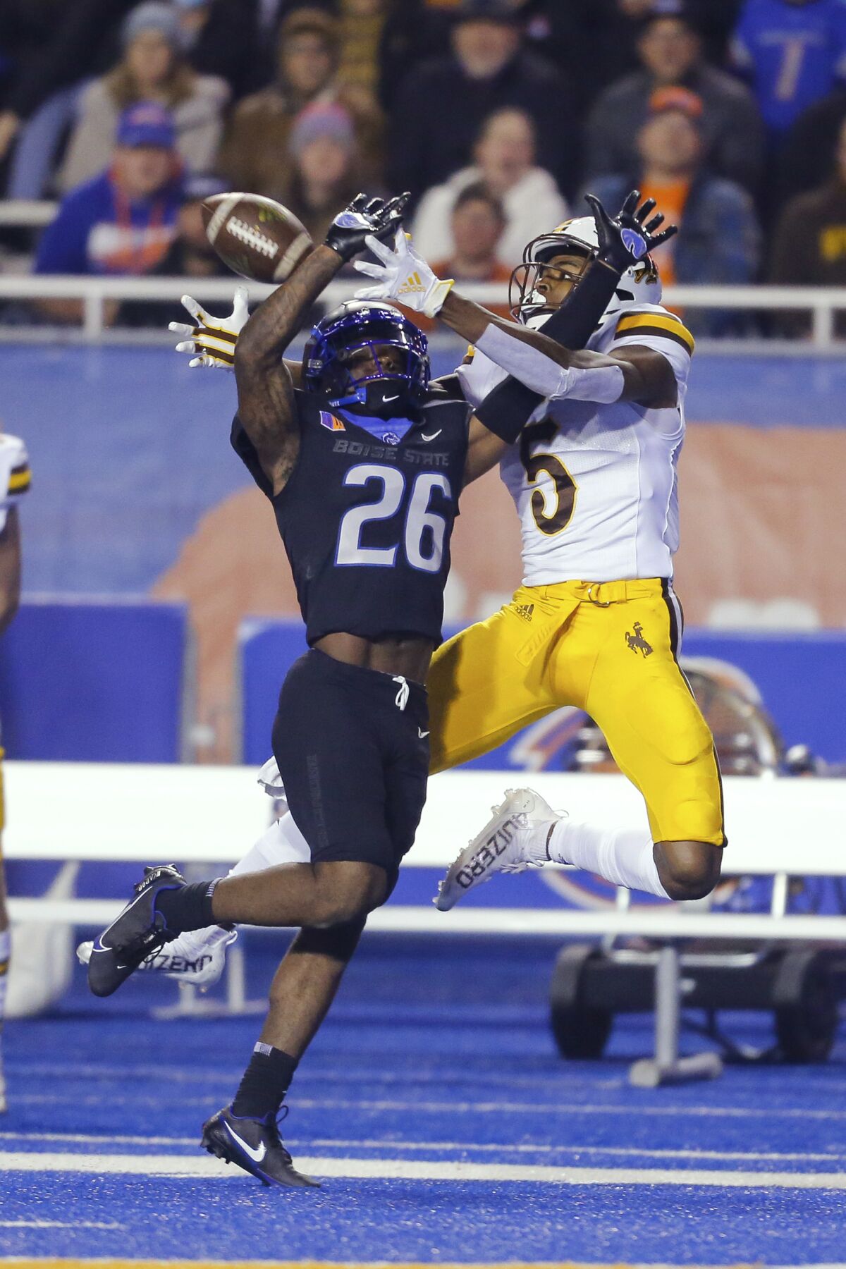 Wyoming wide receiver Isaiah Neyor (5) reaches back for the ball as Boise State cornerback Caleb Biggers (26) defends during the second half of an NCAA college football game Friday, Nov. 12, 2021, in Boise, Idaho. The pass was incomplete. Boise State won 23-13. (AP Photo/Steve Conner)