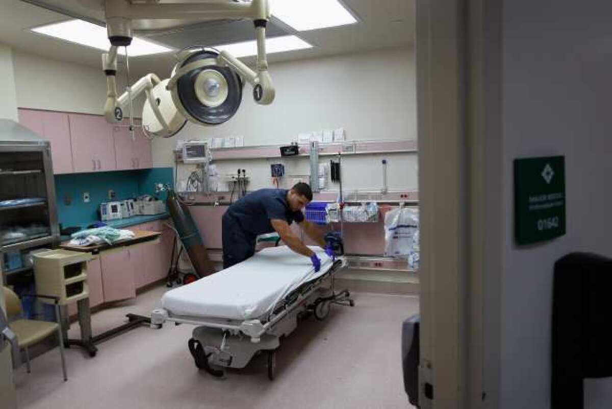 A healthcare worker sets up a hospital room. (Joe Raedle / Getty Images)