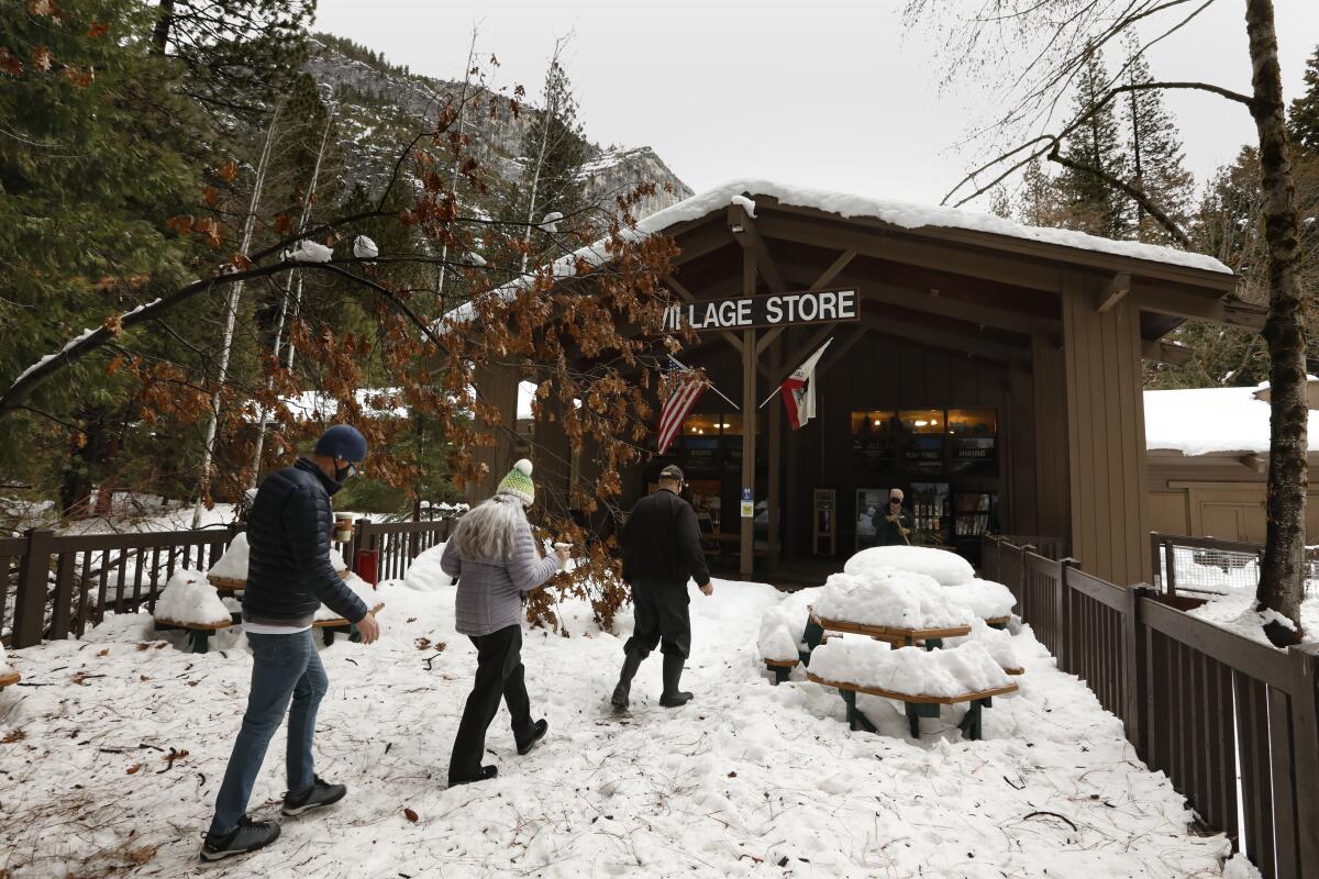 Yosemite Park employees walk through snow to the Village Store. 