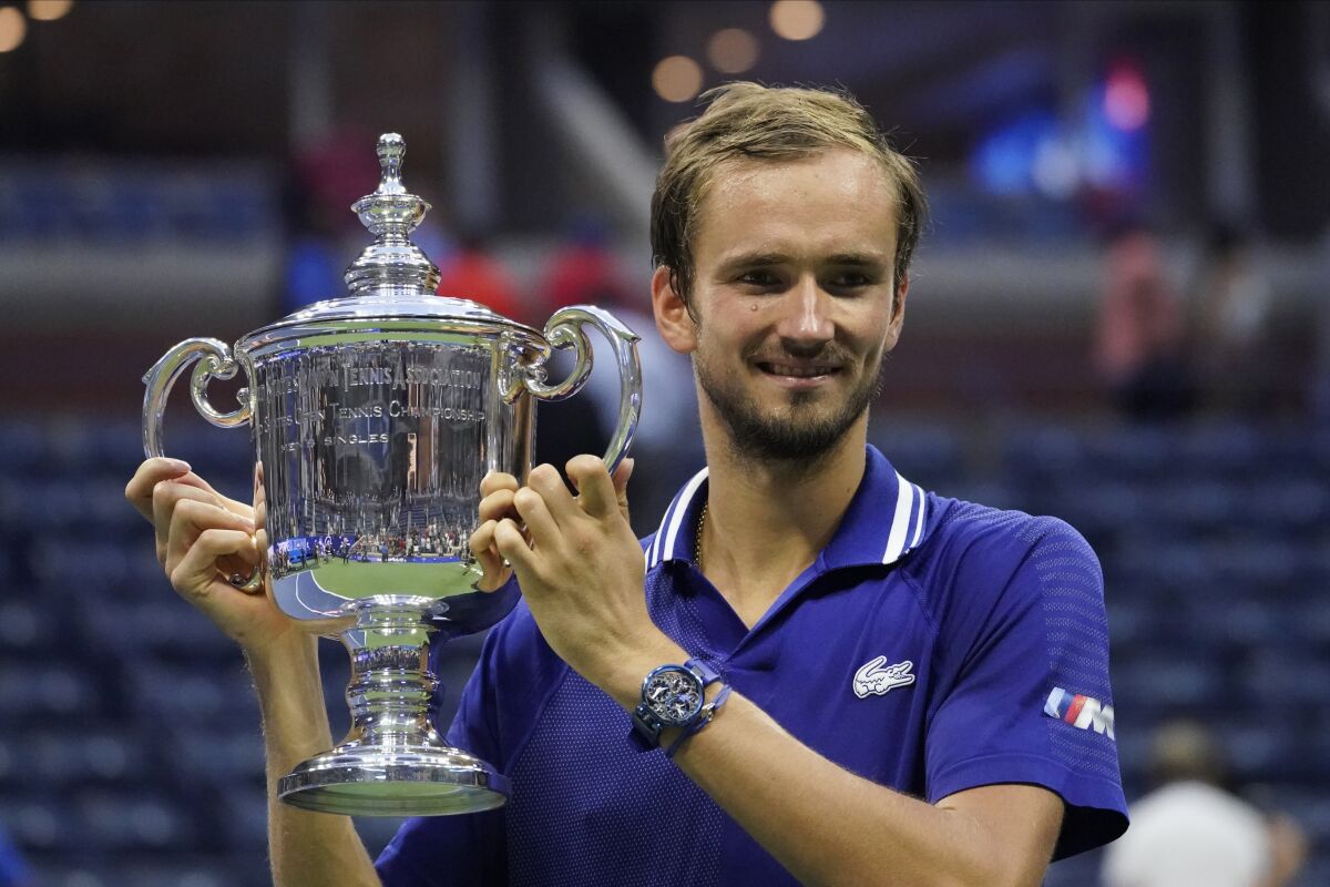 Daniil Medvedev holds up the championship trophy after defeating Novak Djokovic.