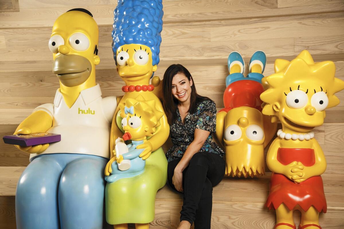Beatrice Springborn, the head of original programming at Hulu, is flanked by "The Simpsons" characters at Hulu headquarters in Santa Monica.