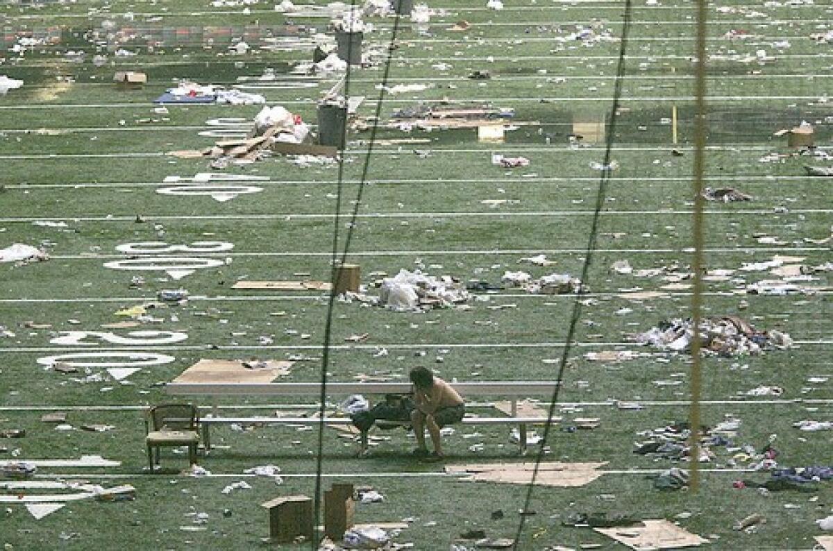 A lone evacuee sits on the field at the Superdome after Hurricane Katrina hit New Orleans in 2005.