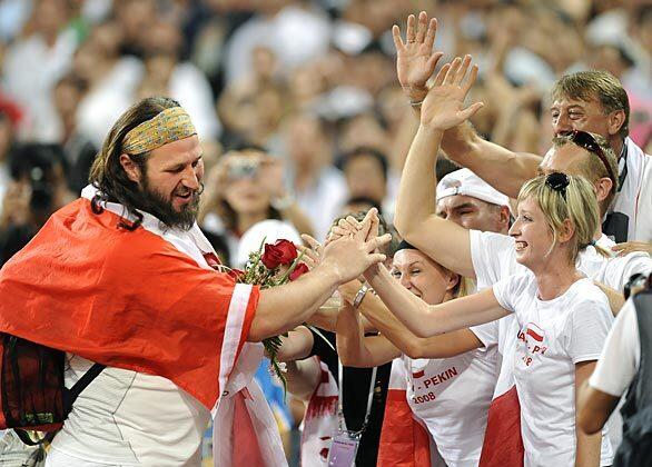 Poland's Tomasz Majewski celebrates with fans after winning the gold medal in the finals of the men's shotput in the 2008 Beijing Olympics.