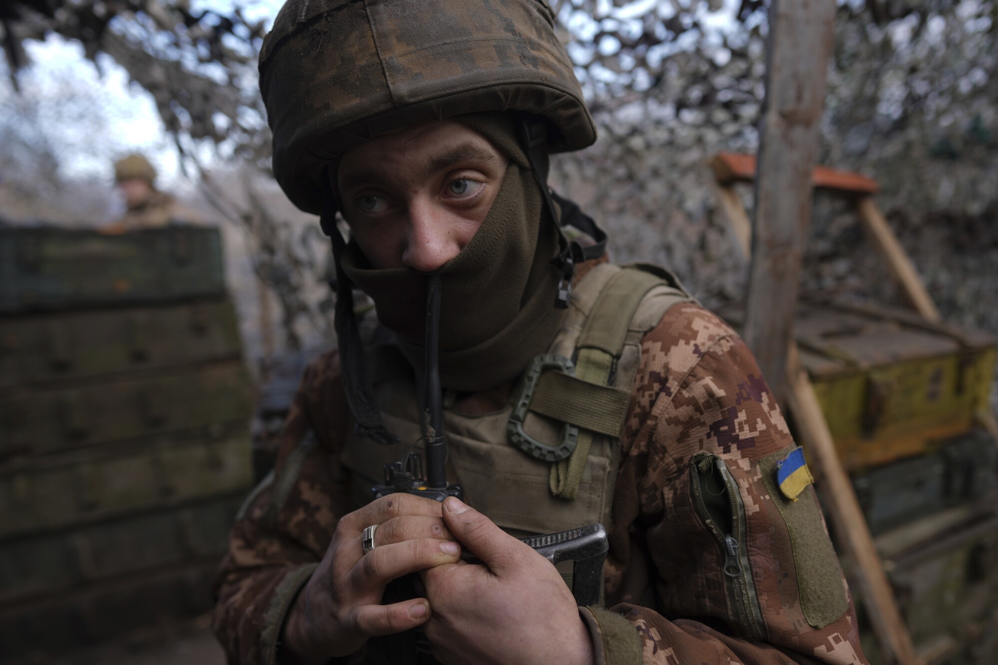 A Ukrainian serviceman speaks on a walkie-talkie at his position