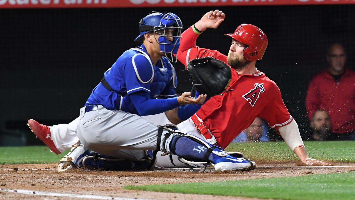 Angels' Kevan Smith beats the tag of Dodgers catcher Austin Barnes during the Freeway Series on Monday in Anaheim.