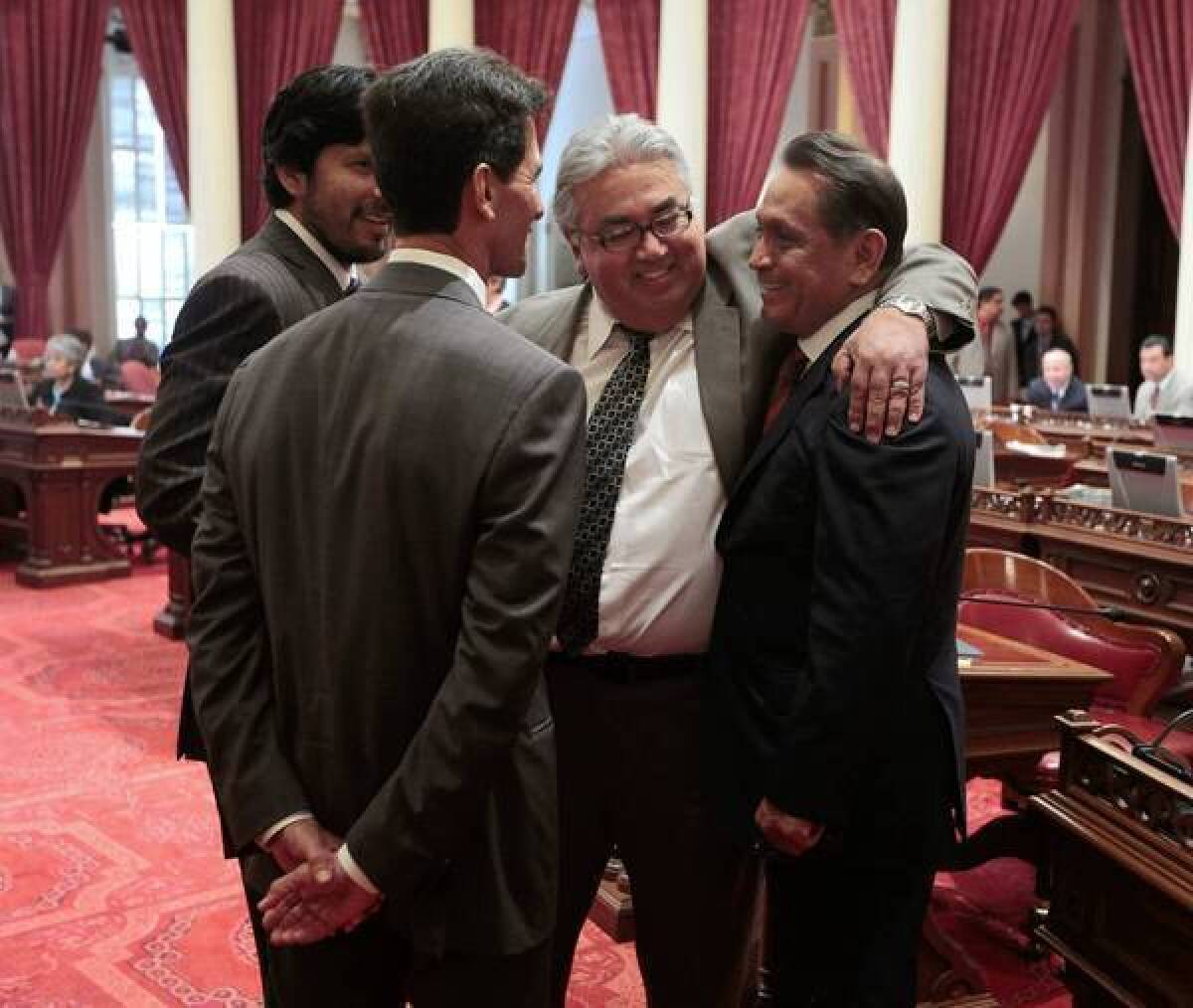 Assemblyman Gil Cedillo, right, is congratulated by state Sens. Kevin de Leon, left, Mark Leno, second from left, and Ron Calderon after the Senate approved his measure last week to allow illegal immigrants to get driver's licenses.