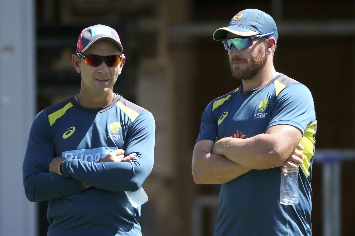 FILE - In this Jan. 1, 2019, file photo, Australia's cricket head coach Justin Langer, left, chats with batsman Aaron Finch during a training session in Sydney. Langer is ready to embrace change to keep his Australian cricket squad on the road as the team prepares to leave Perth on Sunday, Aug. 23, 2020, for England. (AP Photo/Rick Rycroft, File)