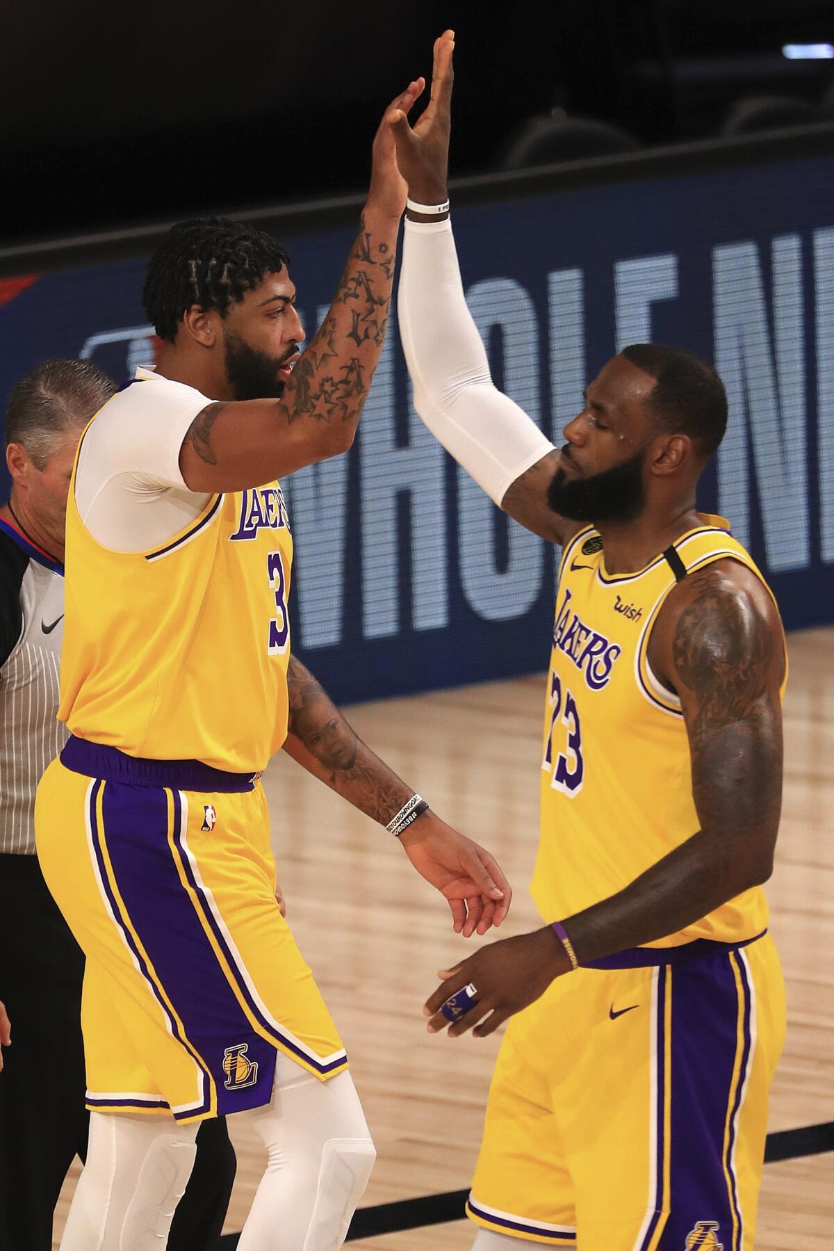 Lakers forwards Anthony Davis (3) and LeBron James (23) high-five during the first quarter.